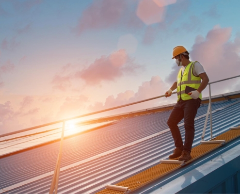 Image of a worker inspecting a commercial metal roof.